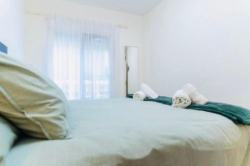 a white bed with towels on it in a bedroom at Fuengirola Centro Histórico. A 200 m de la playa in Fuengirola