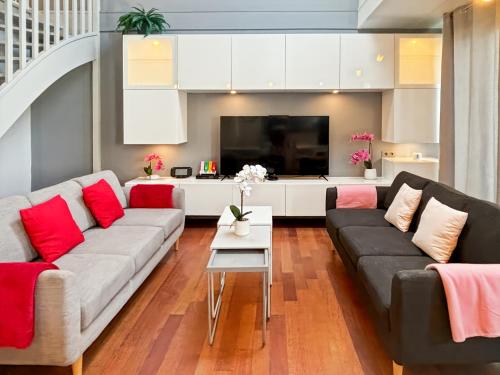 - un salon avec un canapé et des oreillers rouges dans l'établissement Family Duplex Disneyland Paris - Rentaway BnB, à Magny-le-Hongre