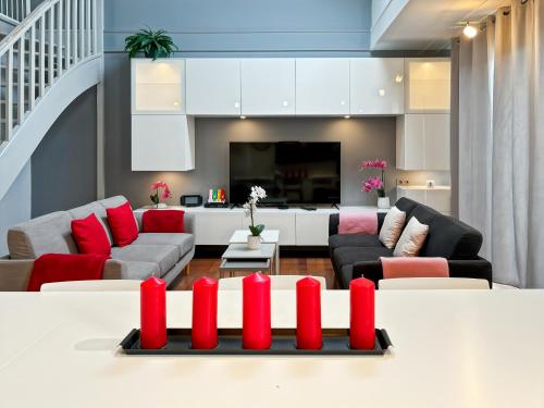 - un salon avec un canapé et une table avec des bougies rouges dans l'établissement Family Duplex Disneyland Paris - Rentaway BnB, à Magny-le-Hongre
