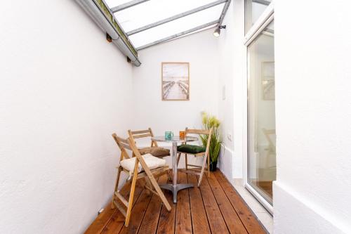 a room with a table and chairs on a wooden floor at Celje City Stay in Celje