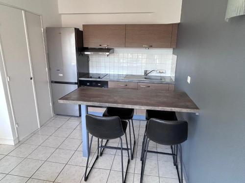 - une cuisine avec un comptoir et des tabourets dans l'établissement centre ville et terrasse, à Brive-la-Gaillarde