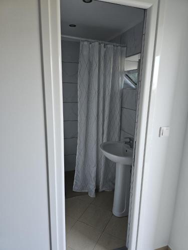 a bathroom with a sink and a shower curtain at Saranda Landscape in Nivicë