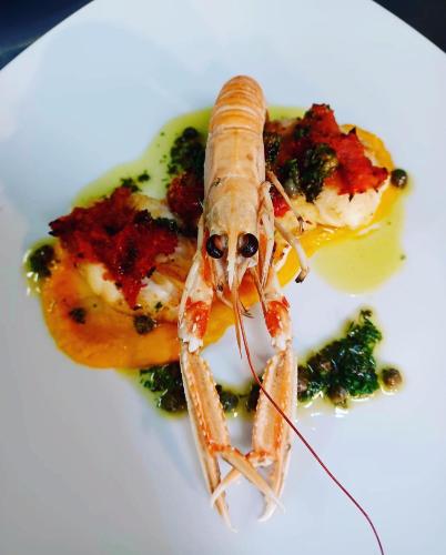 a seafood dish on a white plate with broccoli at Ashes Seafood Restaurant Accommodation in Dingle