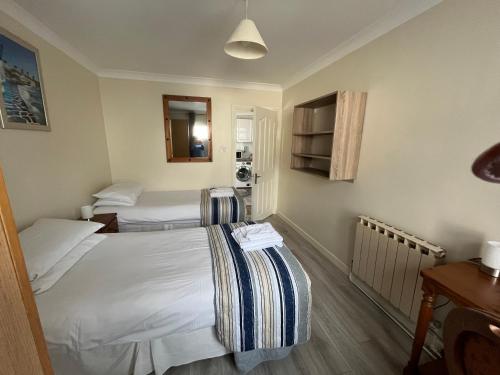 a hotel room with two beds and a table at The Coach House in Feevaghmore