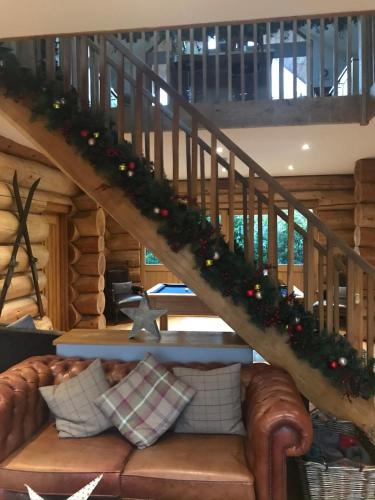 a living room with a couch and a staircase with christmas decorations at Fir Lodge in Kings Lynn