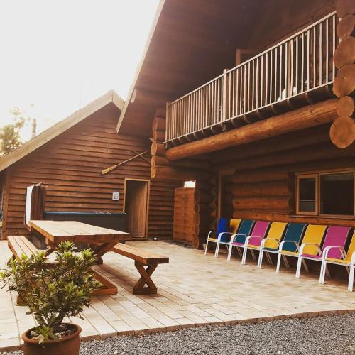 a wooden deck with chairs and a picnic table at Fir Lodge in Kings Lynn