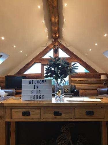 a wooden table with a sign that reads welcome to my farm lodge at Fir Lodge in Kings Lynn