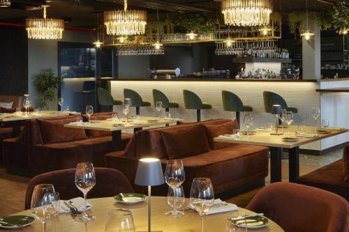 a restaurant with tables and chairs and wine glasses at REVERB by Hard Rock Hamburg in Hamburg
