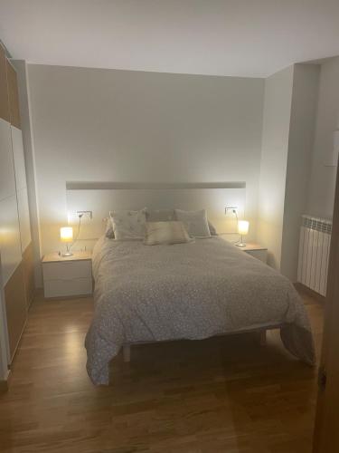 a bedroom with a large bed with two lamps at El Rincón del Ángel in Jaca