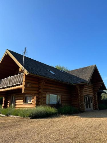 a log cabin with a porch and a roof at Fir Lodge in Kings Lynn