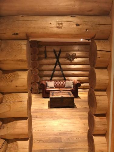 a room with a couch in a log cabin at Fir Lodge in Kings Lynn