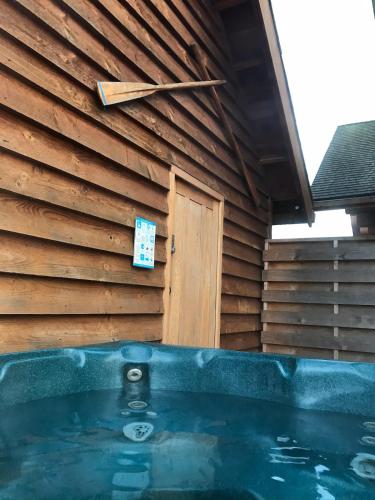 a jacuzzi tub in front of a wooden building at Fir Lodge in Kings Lynn
