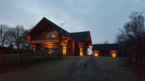 a log cabin with a porch and a deck at Fir Lodge in Kings Lynn