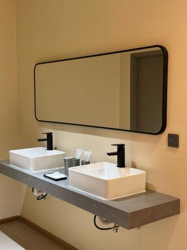 a bathroom with two sinks and a large mirror at Hotel Ivory Papar in Papar