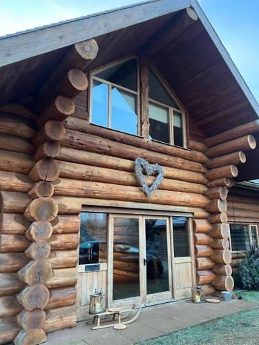 a log cabin with a heart on the side of it at Fir Lodge in Kings Lynn