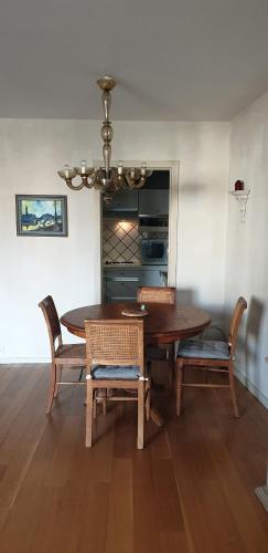 une salle à manger avec une table et des chaises en bois dans l'établissement Appartement chaleureux au cours du 15eme, à Paris