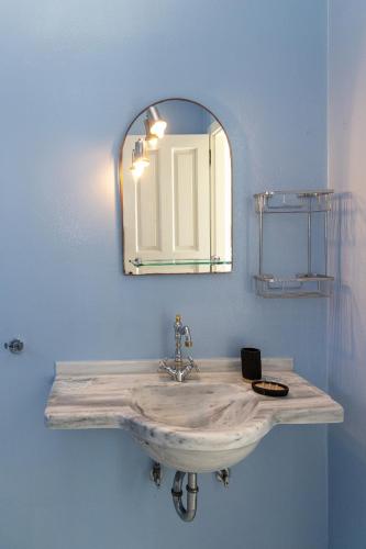 a bathroom with a sink and a mirror at Villa Marble Tinos in Agios Fokas