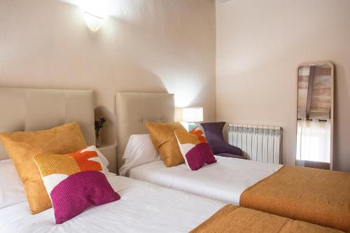 two beds with colorful pillows in a bedroom at Sa Barcella TI 64 in Sineu