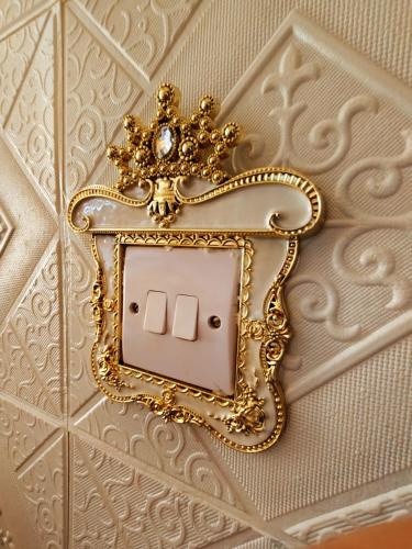 a gold lightswitch with a crown on a wall at Jessica Flat Malta Royal Guesthouse in Cospicua