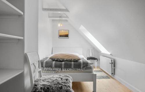 a white bedroom with a bed on a table at 3 Bedroom Awesome Home In Bindslev in Bindslev