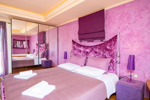 a pink bedroom with a large bed and a mirror at Le Chateau by CorfuΕscapes in Corfu