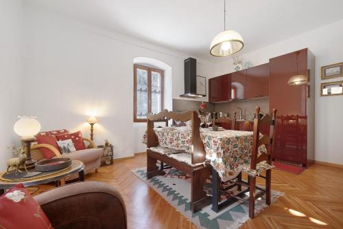 Una sala de estar con una mesa y un comedor. en Appartamento Al Bot, en Spiazzo