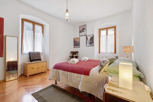 Un dormitorio con una cama, una cómoda y ventanas. en Appartamento Al Bot, en Spiazzo