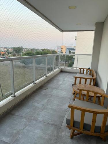 a balcony with two chairs and a view of the water at Departamento 3 Habitaciones Zona Cincuentenario in Formosa