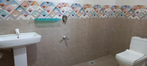 a bathroom with a white toilet and a sink at Vibeesh Villa in Yelagiri