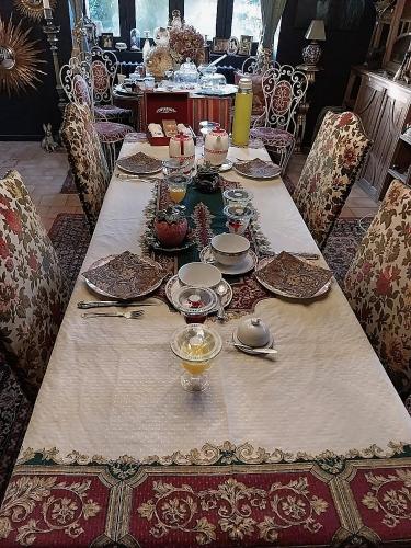 - une grande table avec des assiettes et de la vaisselle dans l'établissement Ferme de la Dorvallière, à Cavagnac