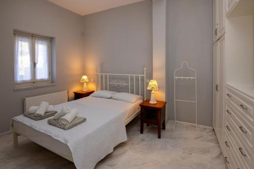 a bedroom with a bed with two towels on it at Villa Marble Tinos in Agios Fokas