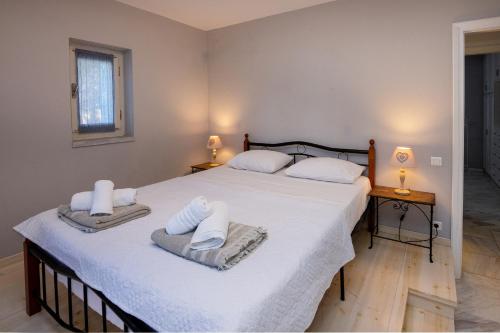 a bedroom with two beds with towels on them at Villa Marble Tinos in Agios Fokas
