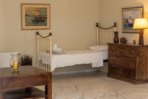 a bedroom with a bed and a wooden table at Villa Marble Tinos in Agios Fokas