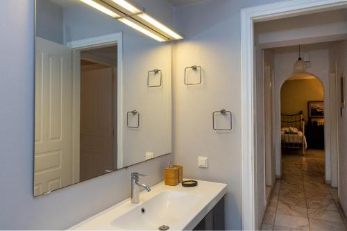 a bathroom with a sink and a large mirror at Villa Marble Tinos in Agios Fokas