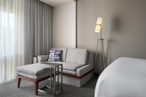 a room with a couch and a chair and a bed at Courtyard by Marriott Fayetteville Fort Liberty - Spring Lake in Spring Lake