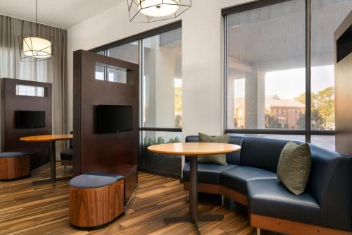 a waiting room with a couch and a table at Courtyard by Marriott Fayetteville Fort Liberty - Spring Lake in Spring Lake