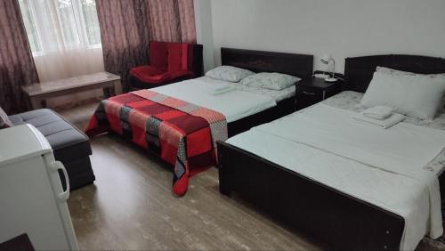 a hotel room with two beds and a chair at Villa Royal House in Makhinjauri
