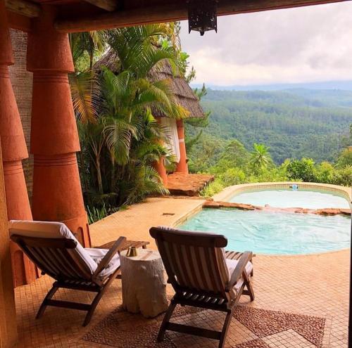 two chairs sitting next to a swimming pool at Timamoon Lodge in Hazyview