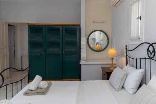 a bedroom with a green door and a bed at Villa Marble Tinos in Agios Fokas