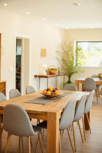 a wooden table with chairs and a bowl of fruit on it at Casa de Algar - Enoturismo in Castelo de Paiva