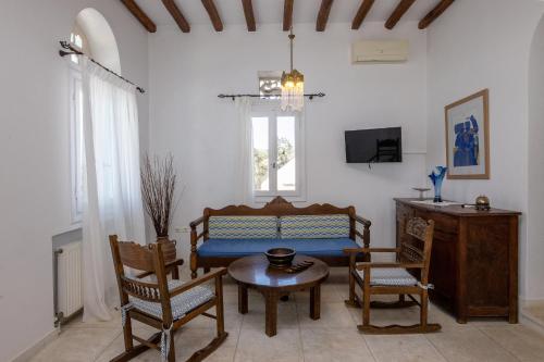 a living room with a couch and chairs and a table at Villa Marble Tinos in Agios Fokas