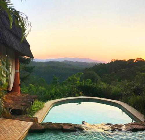 a swimming pool with a view of the mountains at Timamoon Lodge in Hazyview