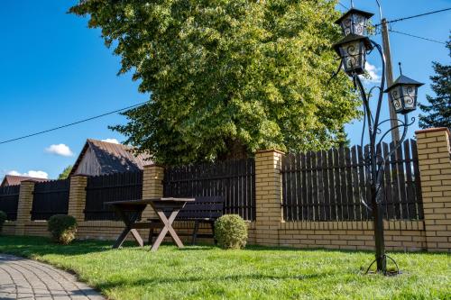 a park with a bench and a fence and a table at Siedlisko Leszczewek in Leszczewek