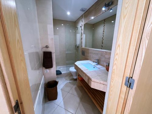 a bathroom with a sink and a toilet and a mirror at Moradia Fantástica com Piscina a 5 min da Praia in Monte Gordo