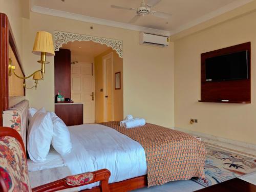 a hotel room with a bed and a television at Gauri Gangaa in Haridwār