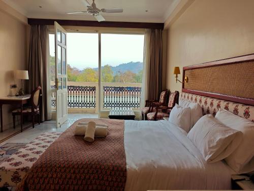 a bedroom with a large bed with a large window at Gauri Gangaa in Haridwār