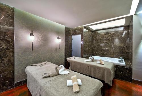 a bathroom with two beds and a bath tub at Uranus Istanbul Topkapi in Istanbul