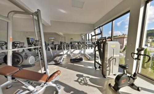 a gym with a lot of treadmills and ellipticals at Hotel SPA Faltom Gdynia Rumia in Rumia