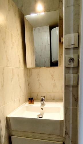 une salle de bain avec un lavabo et un miroir dans l'établissement Studio cosy Balcon Aperçu mer, à Antibes