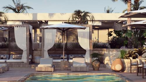 a resort with a pool and chairs and an umbrella at Hotel Indigo Gandia Beach by IHG in Gandía